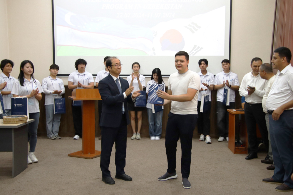 황완식 학생처장이 타슈켄트 교통대 학생에게 학교 굿즈를 전달하고 있다